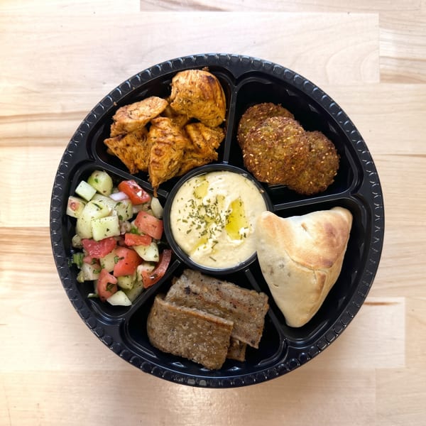 Assorted Mediterranean platter with chicken, falafel, hummus, salad, gyro meat, and a pastry.